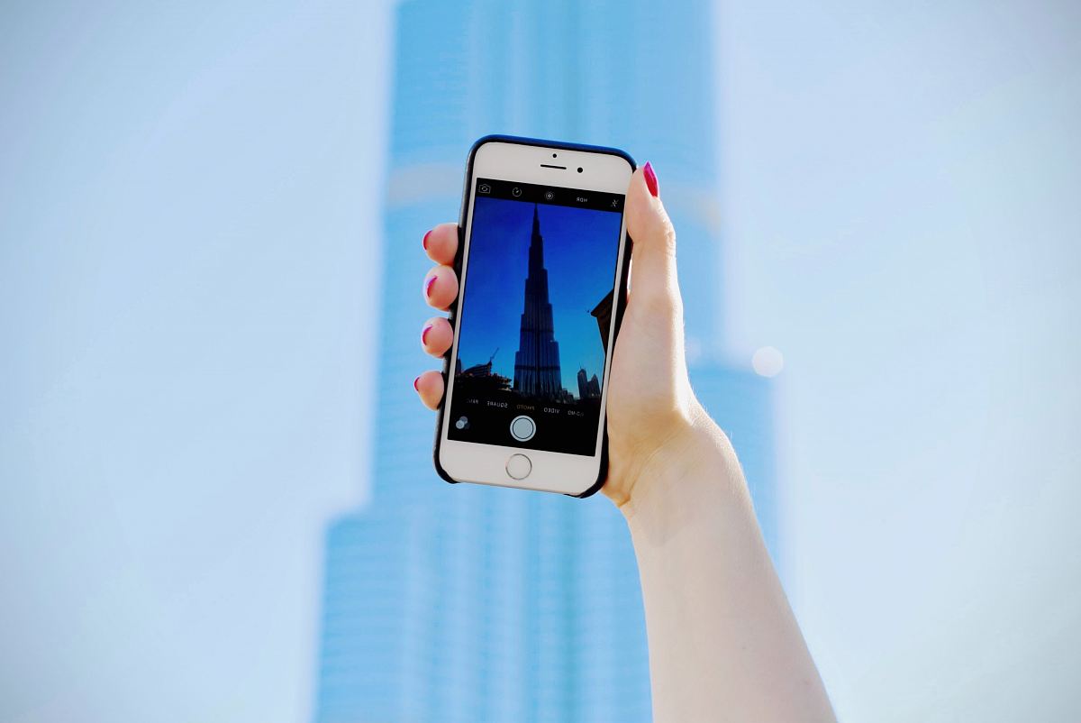 person holding silver iPhone 6 and black case