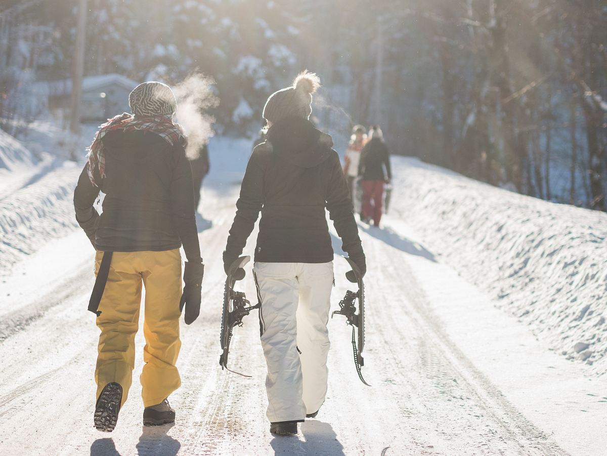 person holding snow ski blades while walking on snowy mountain during daytime