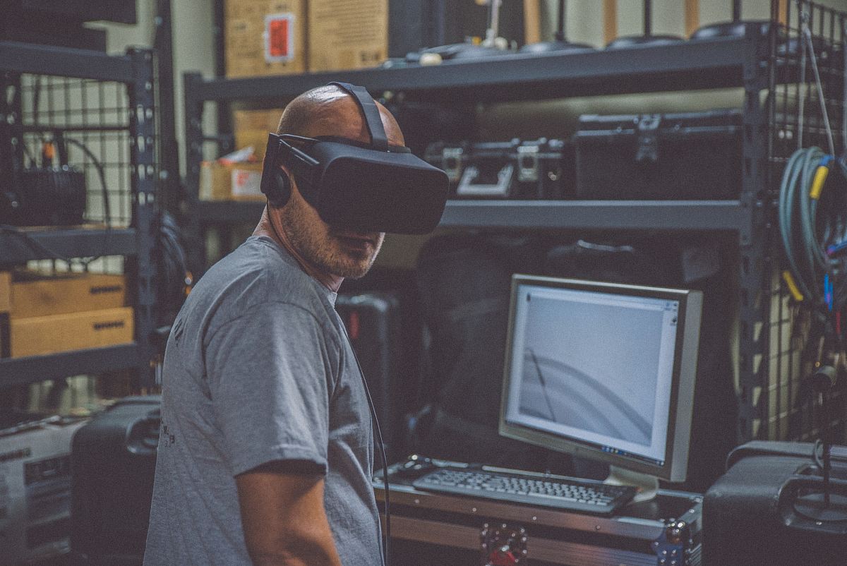 person using black VR Headset in front of computer