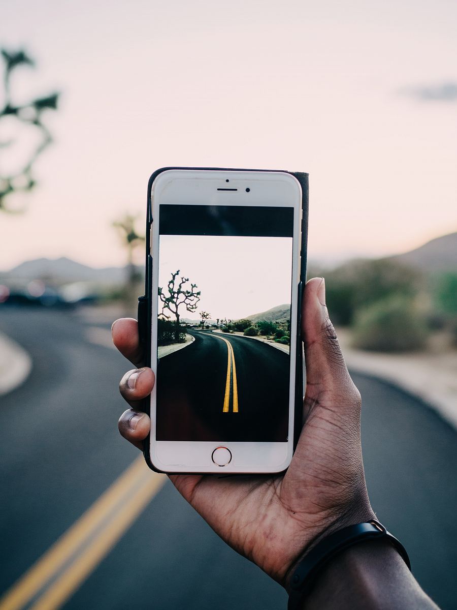 person using gold iPhone 6 capturing road