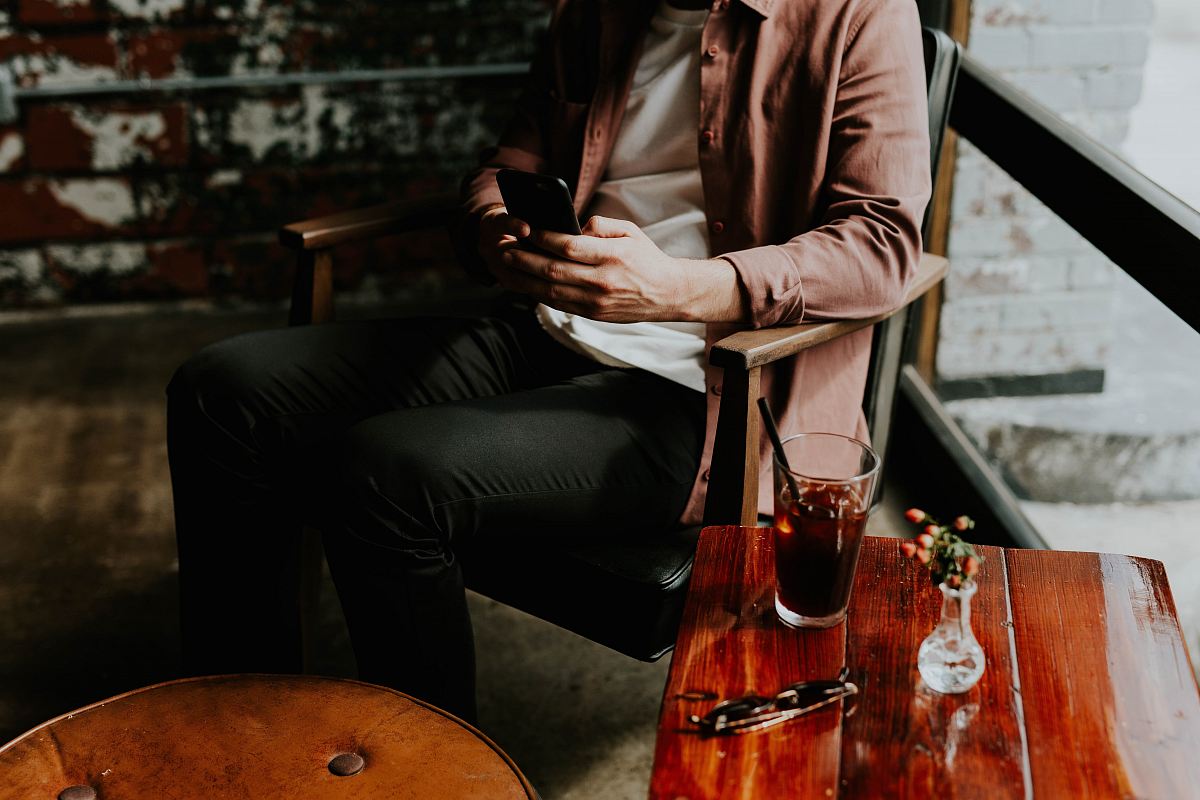 person using smartphone sitting on chair
