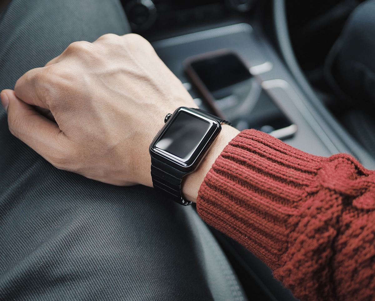 person wearing black case Apple Watch with white Sport Band