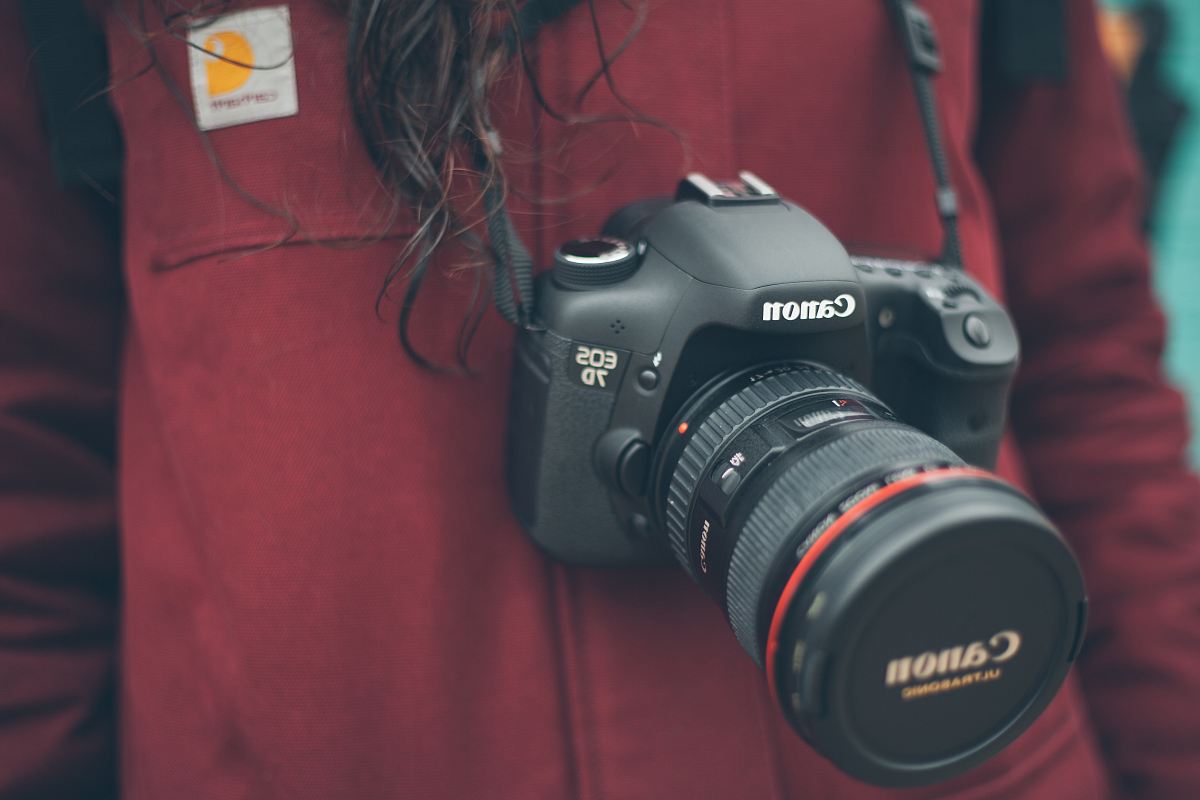 person wearing Canon DSLR camera