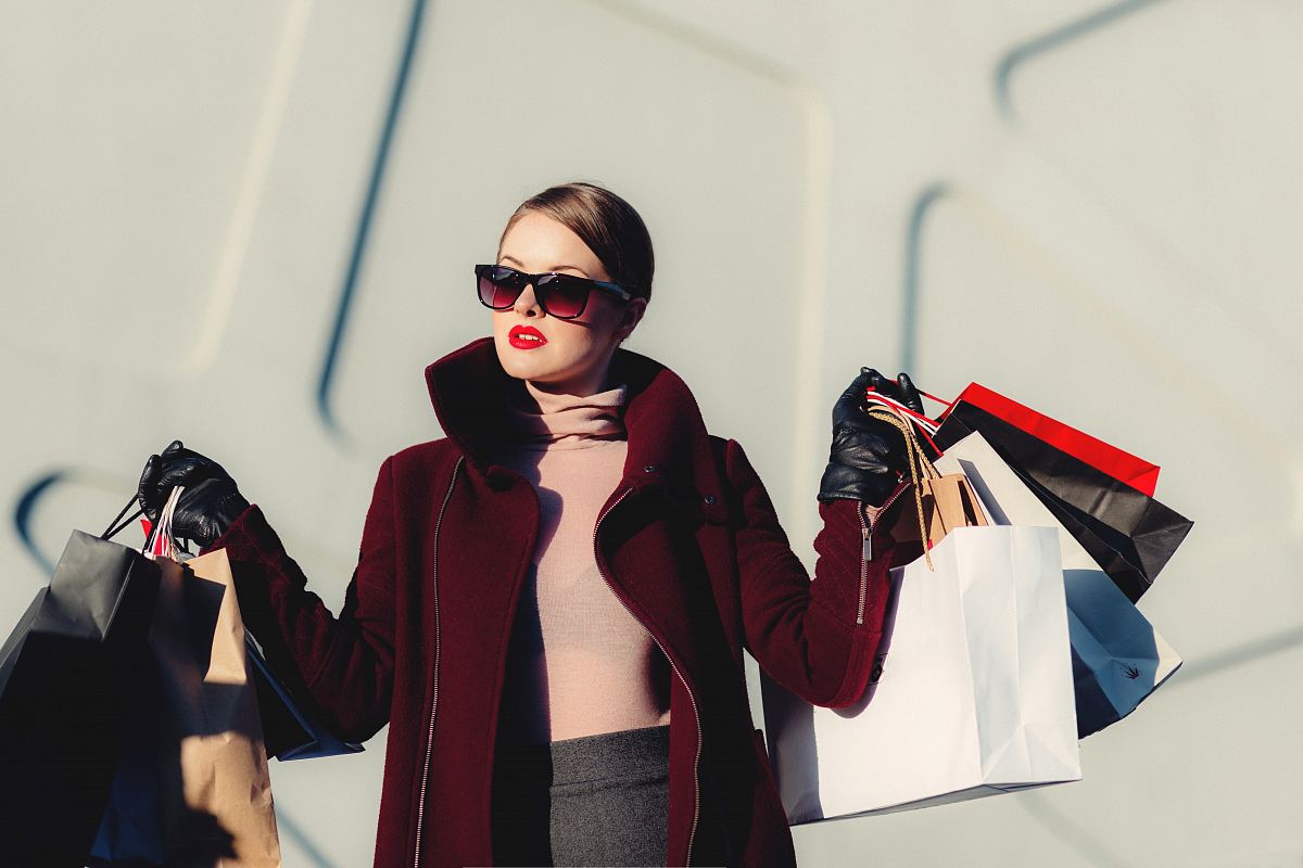photo of woman holding white and black paper bags