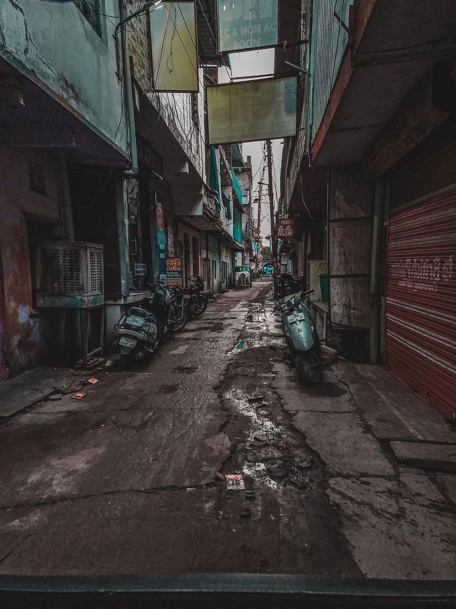 photography of motor scooter parked beside road during daytime