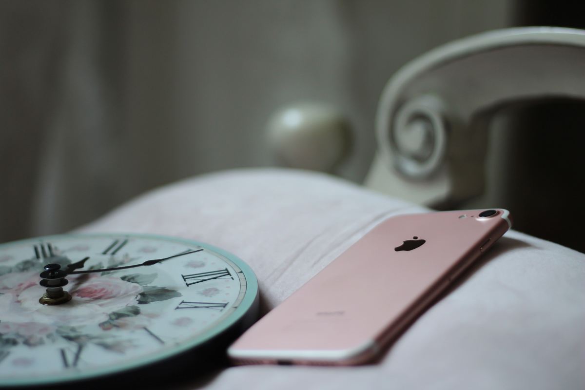 rose gold iPhone 8 near round analog clock