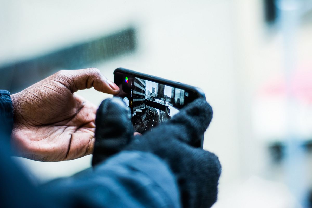 selective focus photography of person taking picture of the road