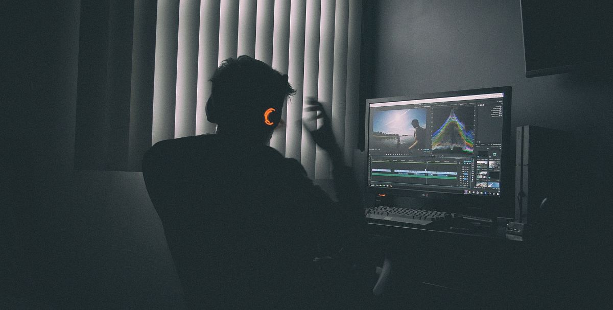 shallow focus photography of man listing to music in front of the computer