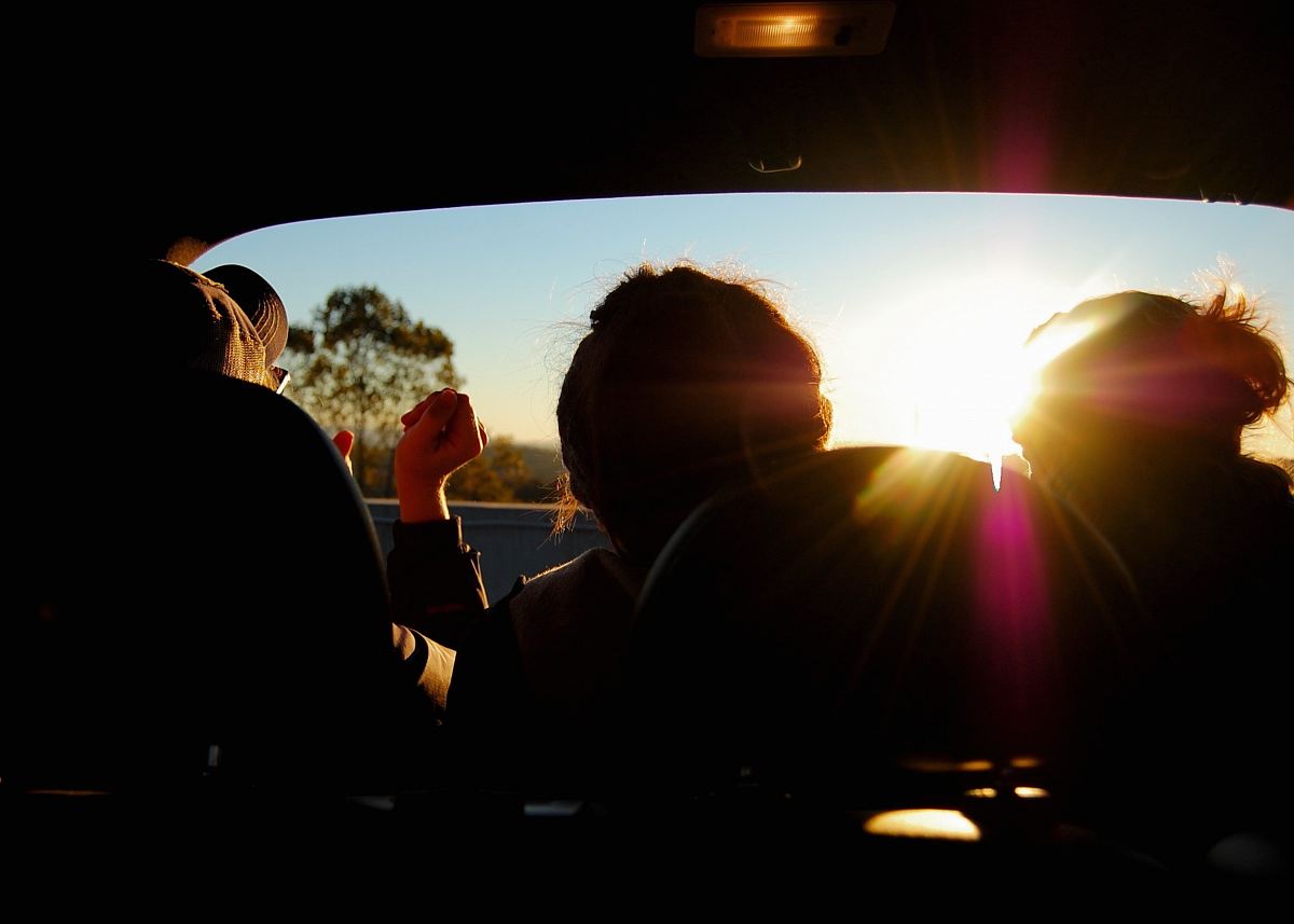 silhouette of three person inside car