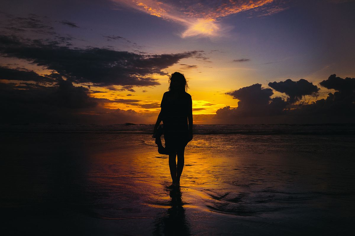 silhouette of woman standing on seashore