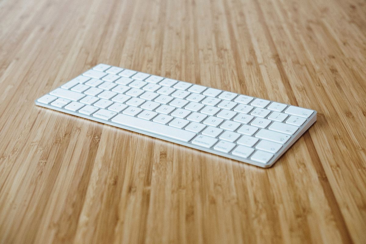 silver and white keyboard on brown wooden surface