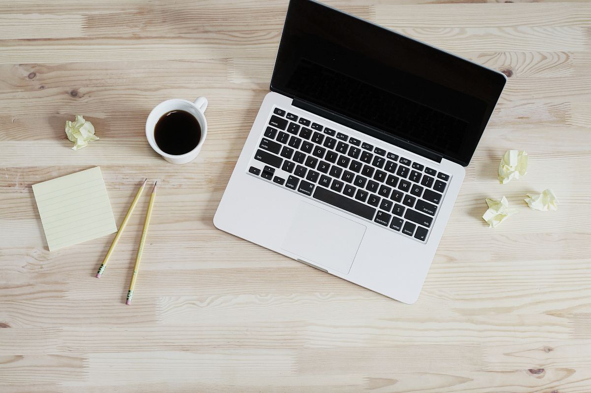 turned off MacBook Pro beside white ceramic mug filled with coffee