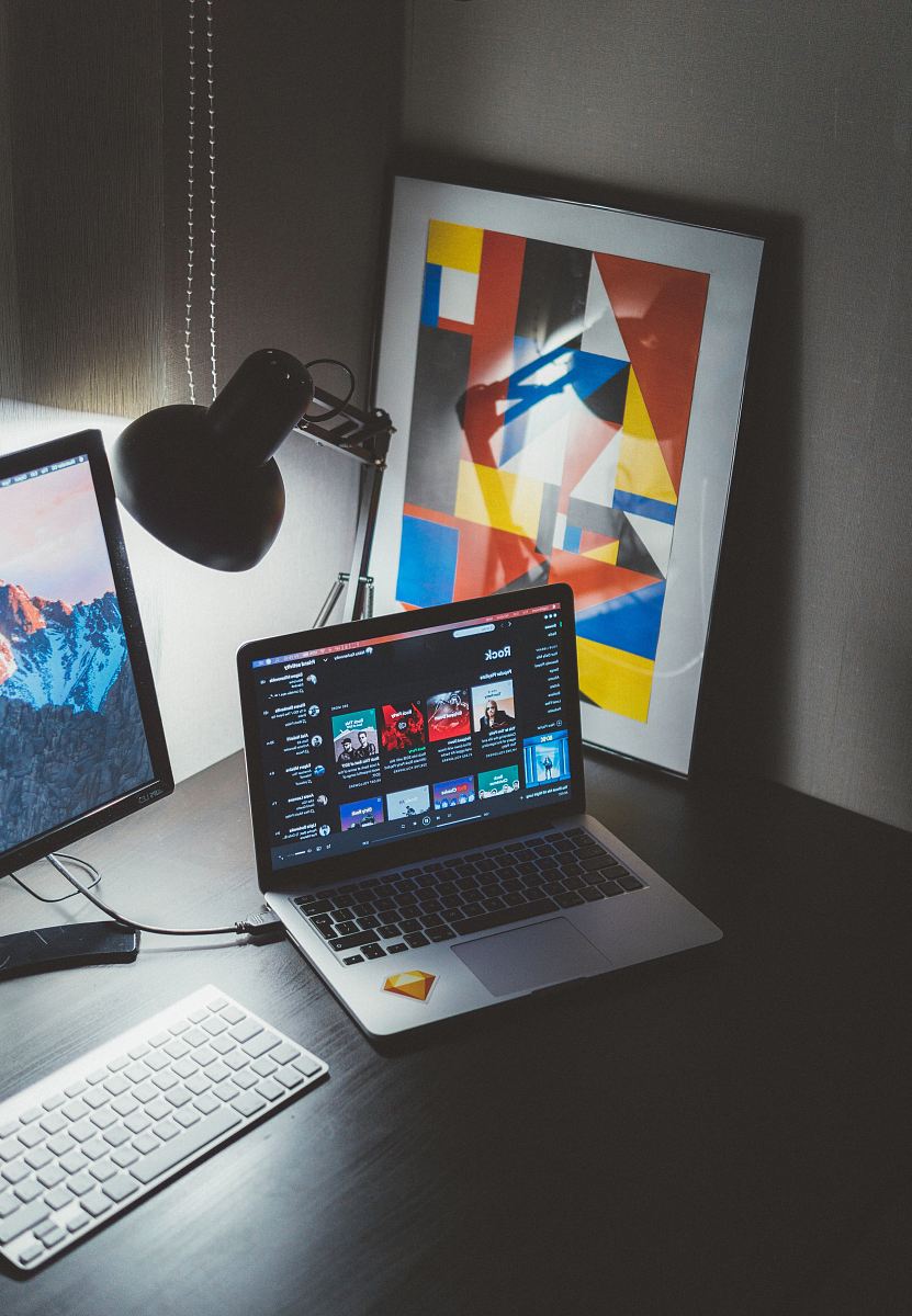 turned on MacBook on table beside iMac