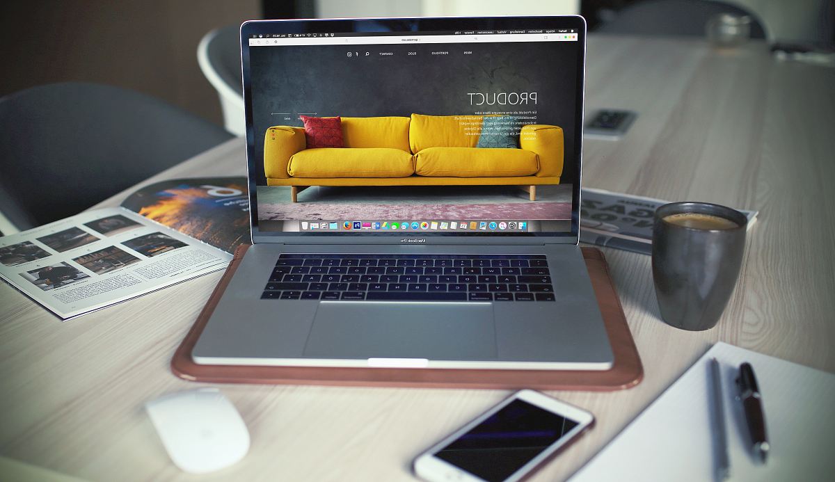 turned on MacBook Pro beside gray mug