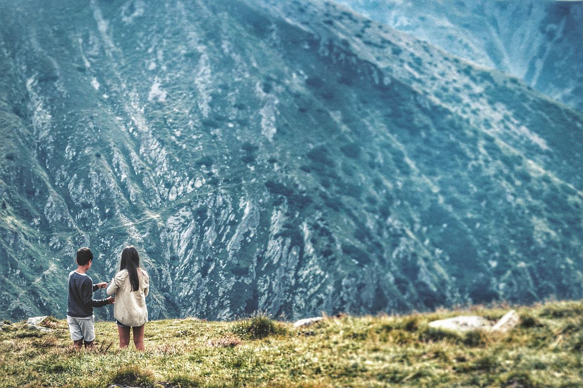 Capture the essence of love and adventure with this stunning image of a couple standing together against a breathtaking mountain backdrop. This scene reflects the tranquility of nature and the joy of companionship, making it an ideal choice for travel blogs, relationship articles, and outdoor adventure promotions. Perfect for inspiring wanderlust and romantic themes, this photograph invites viewers to dream about their own adventures in the great outdoors.