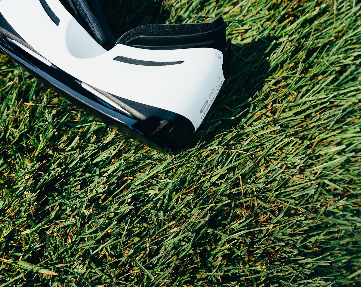 white and black VR Box headset on green grass field