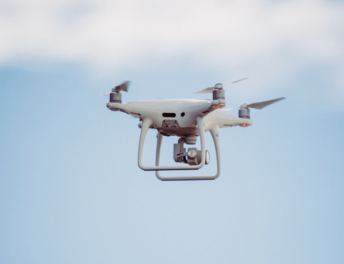 white DJI drone in mid air