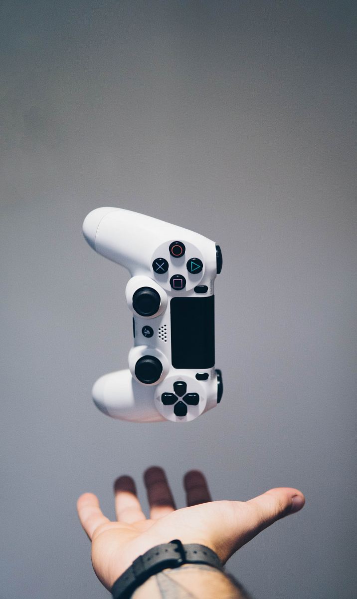 white Sony PS4 DualShock controller over person's palm