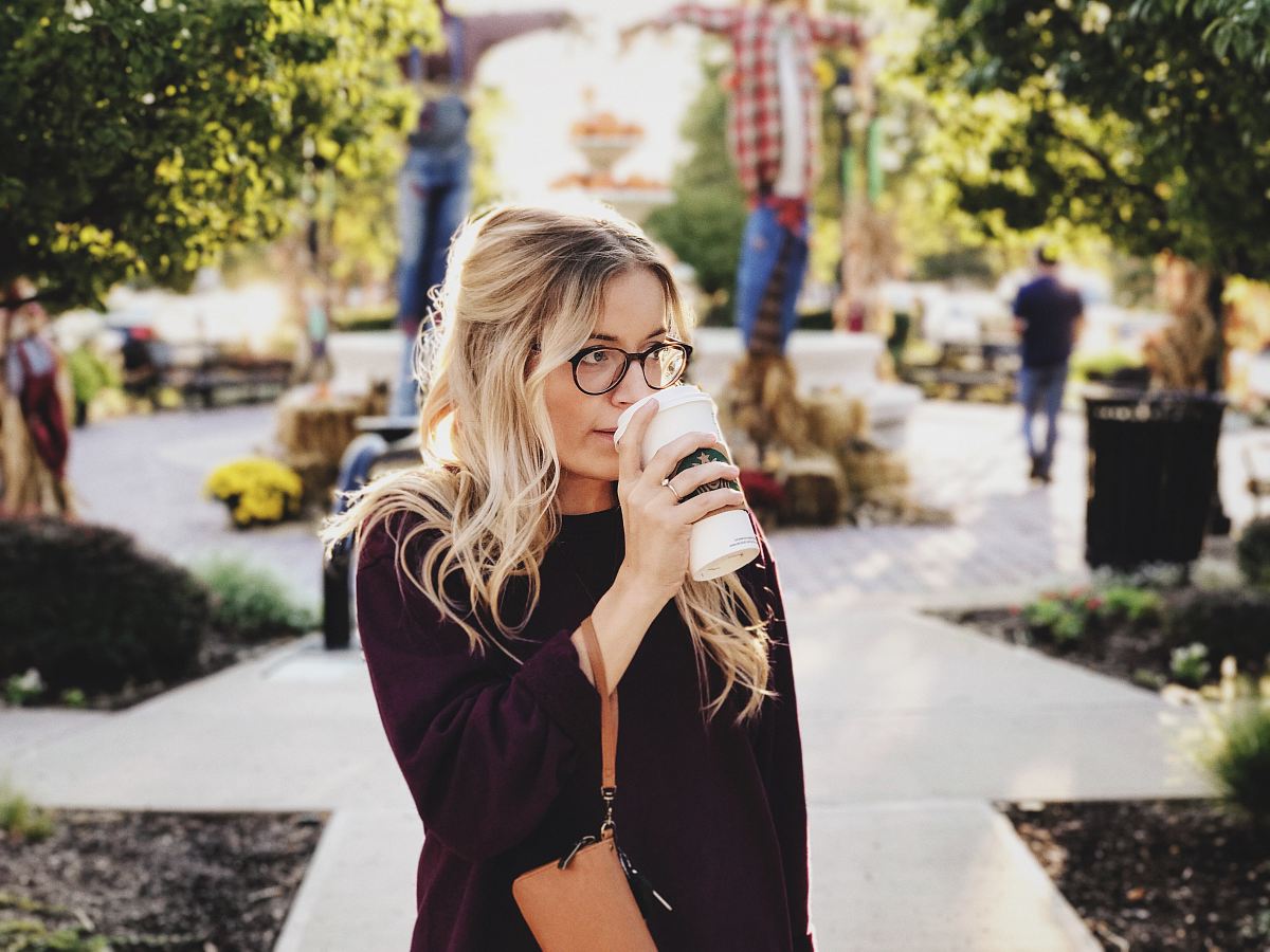 woman drinking on white cup