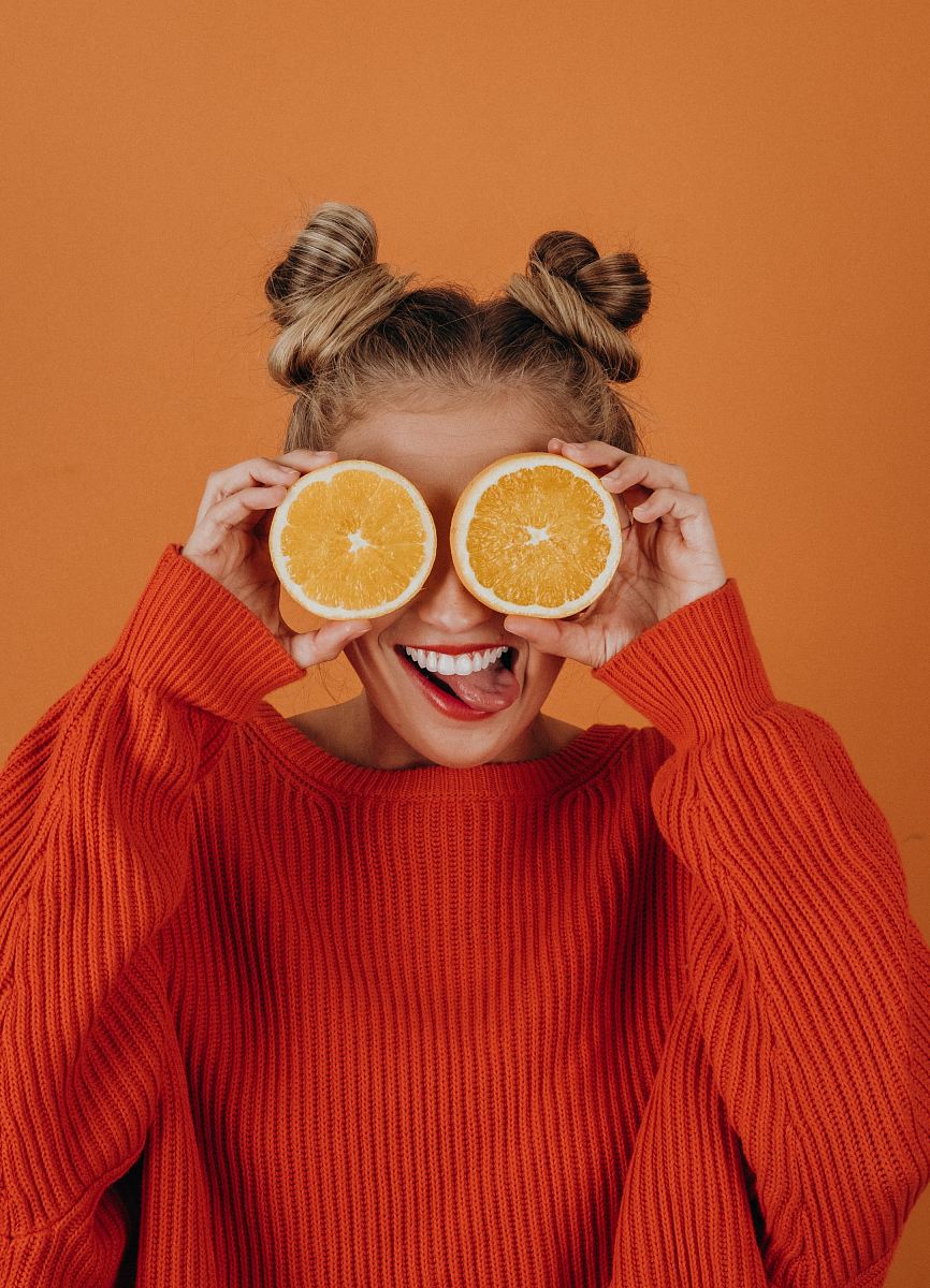 woman in red knit sweater holding lemon