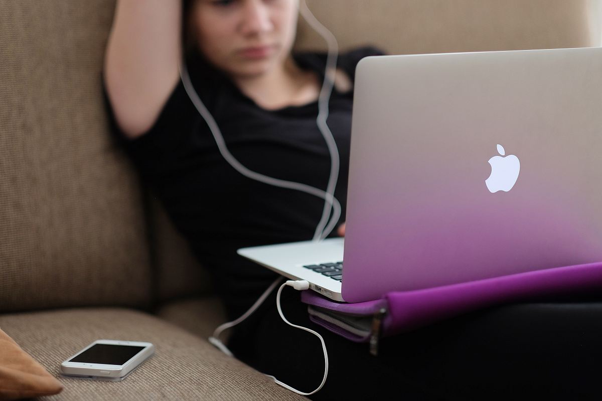 woman sitting on sofa with MacBook Air