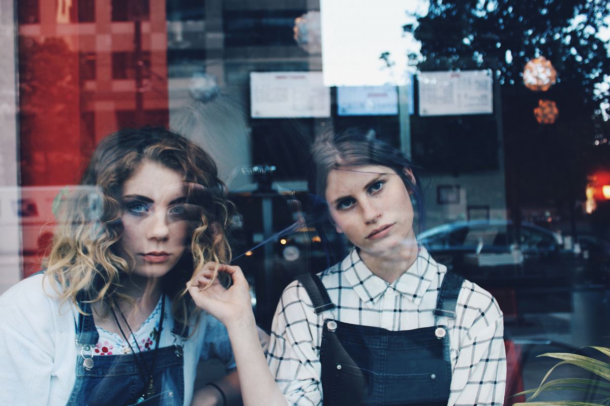woman standing beside woman in blue dungaree