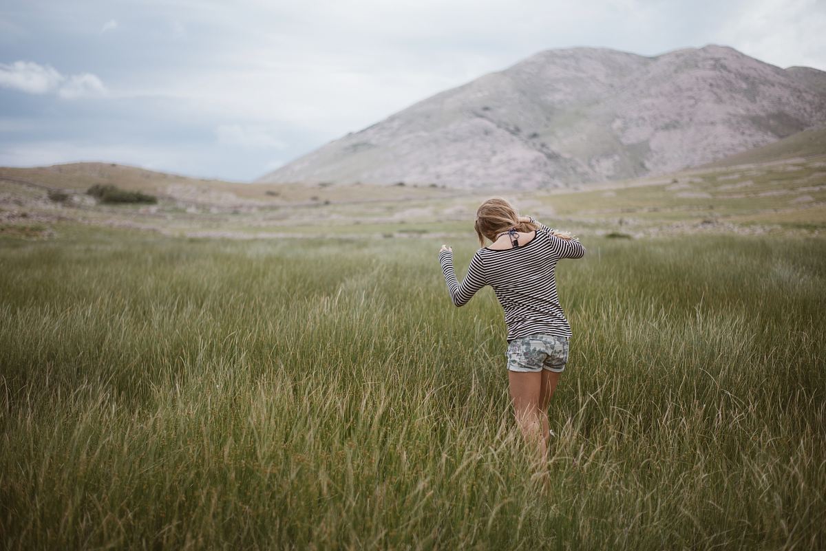 woman walking on grass field