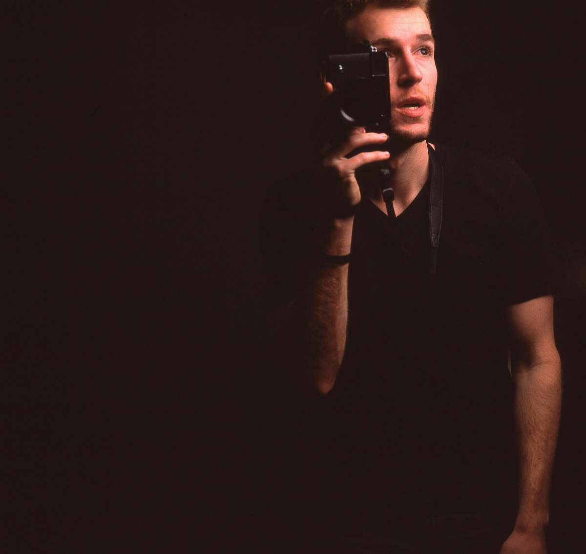 person man wearing black v-neck t-shirt holding smartphone black