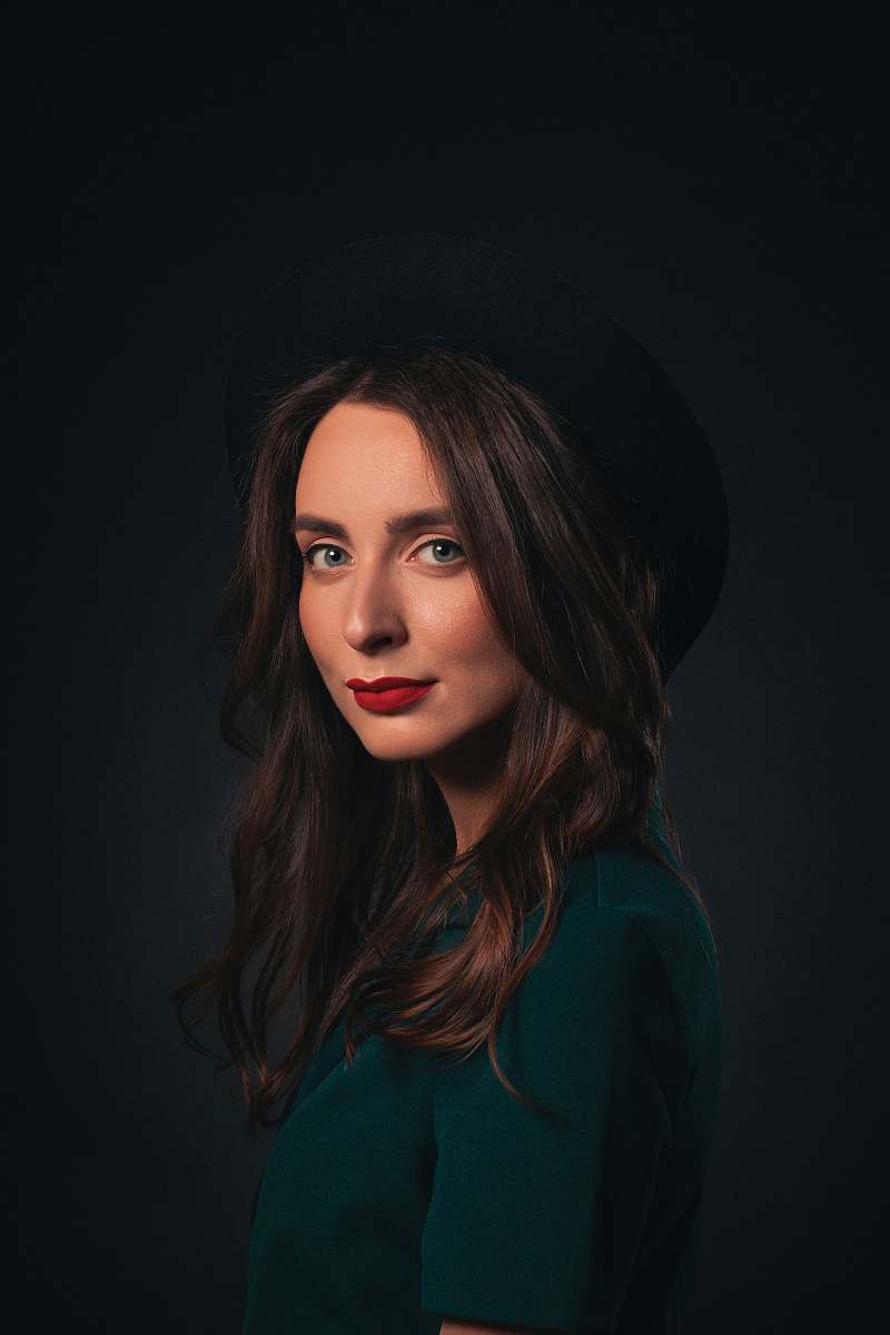 human woman in black hat and green shirt face