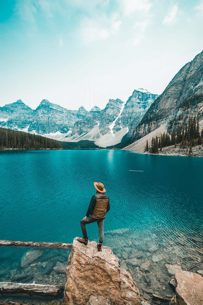 nature man standing on rock near lake mountain
