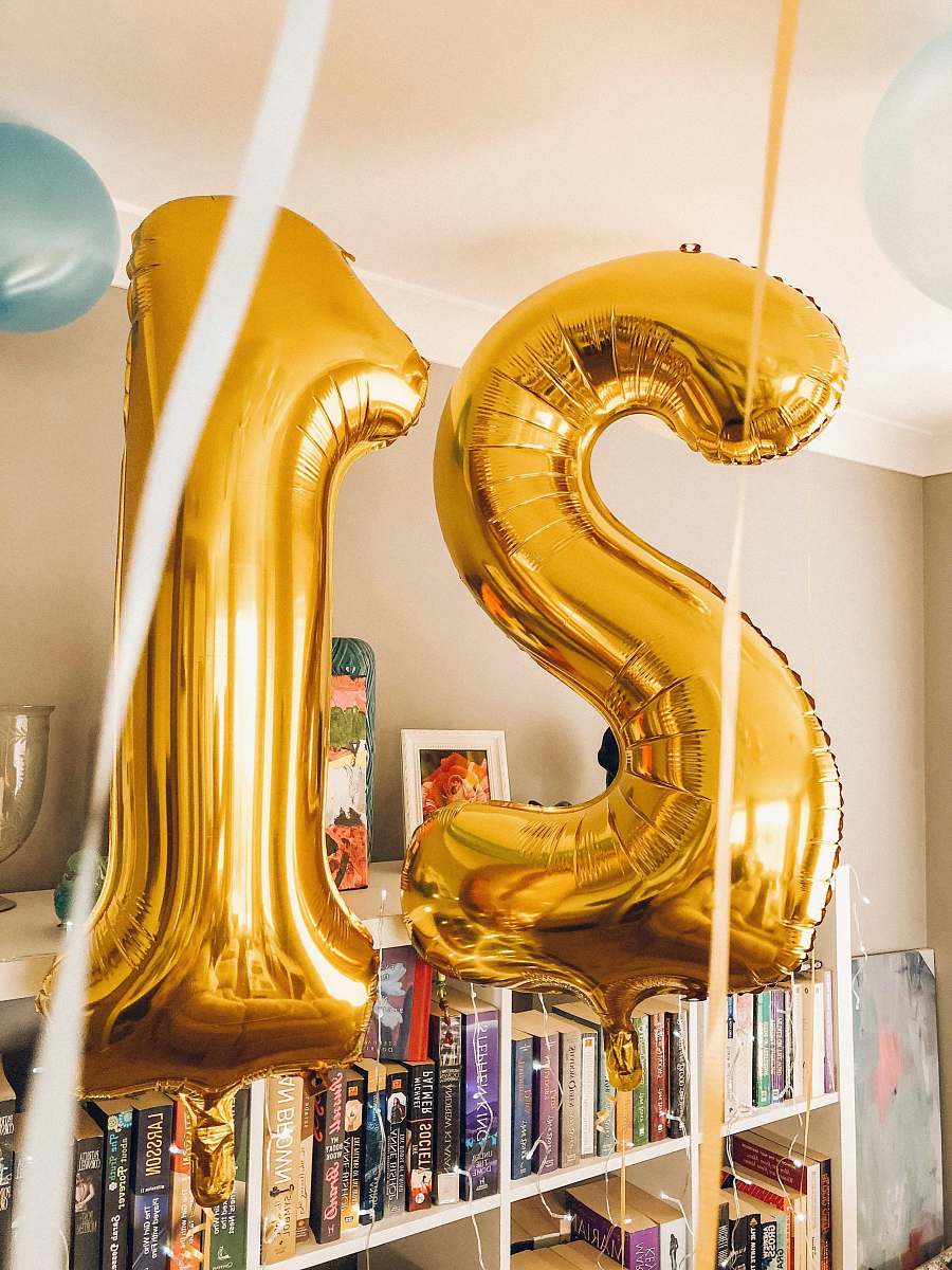 21 brass-colored 21 foil balloons inside room balloon