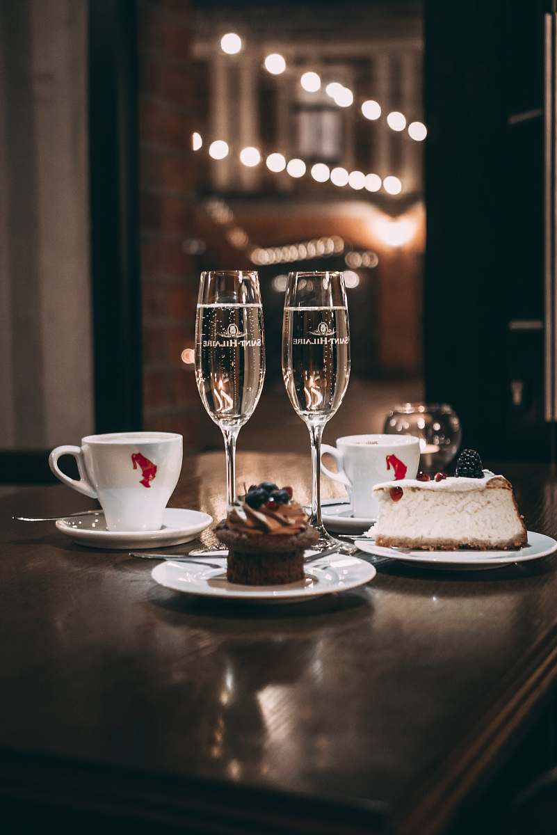 dessert two champagne flute glass beside sliced cake and cupcake roma cafe