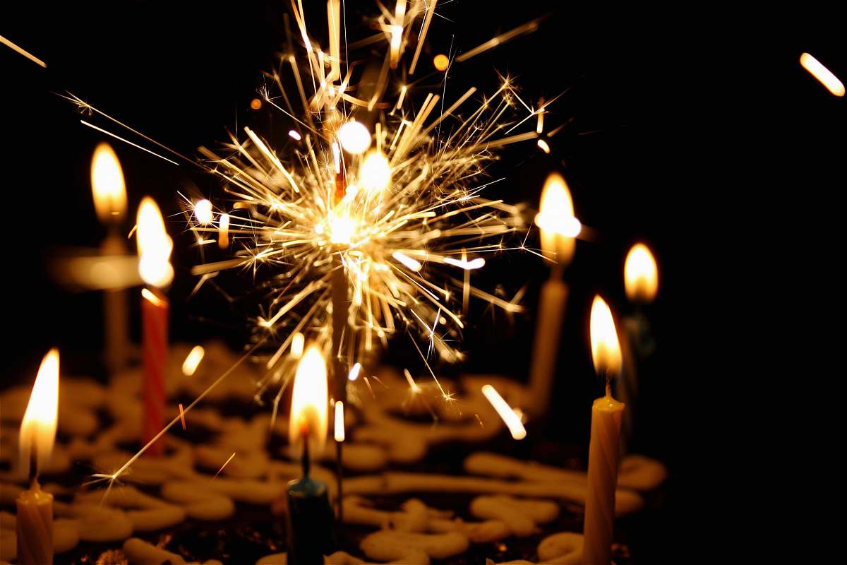 fire close up photography of sparkler beside candles flame