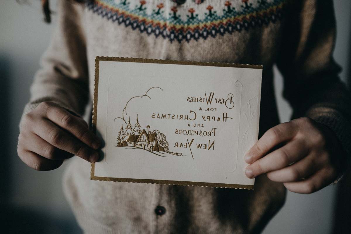 grey person holding white and brown card text