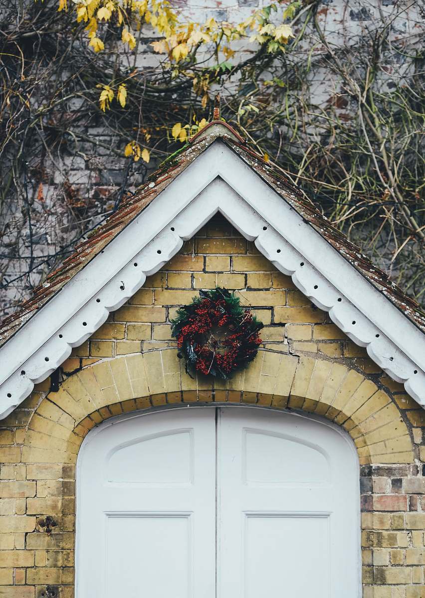 door red flower wreath over door festive