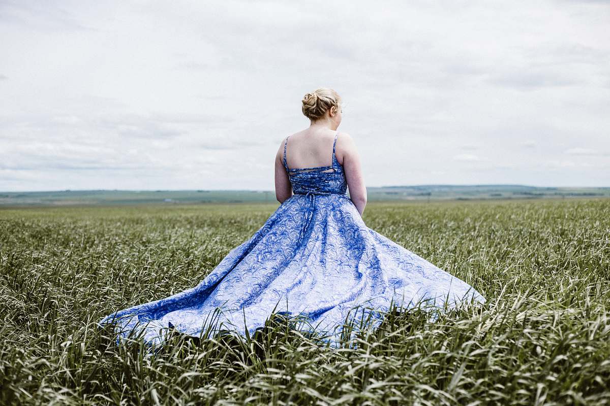 apparel woman standing on green grass field gown