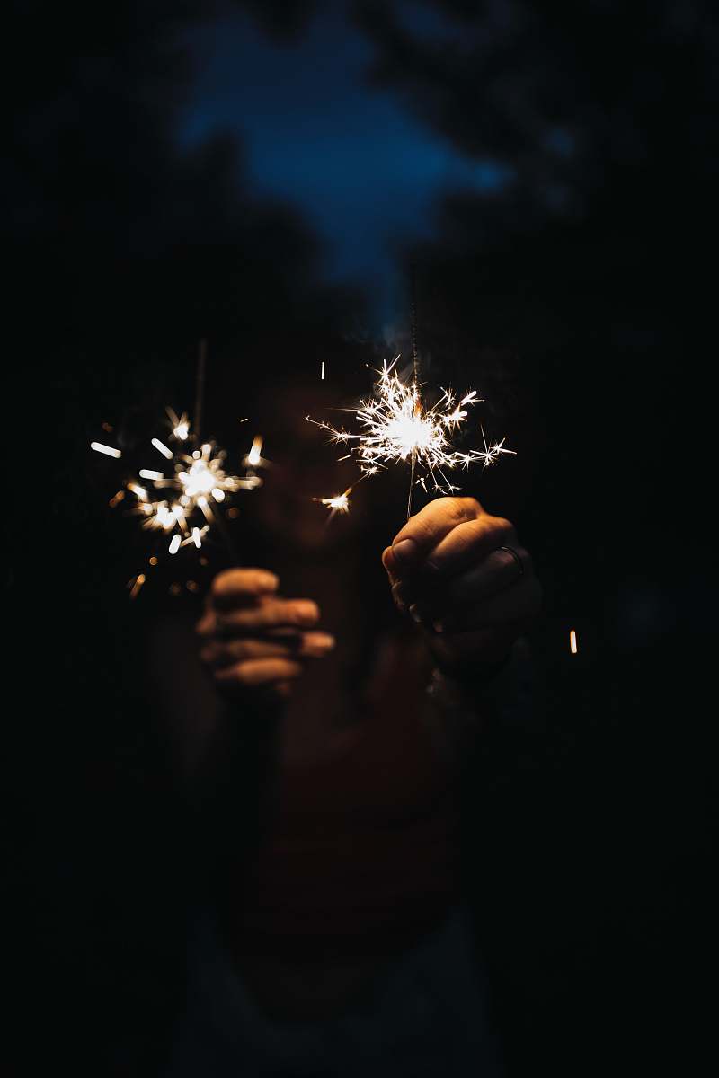 night person holding firecrackers during nighttime outdoors