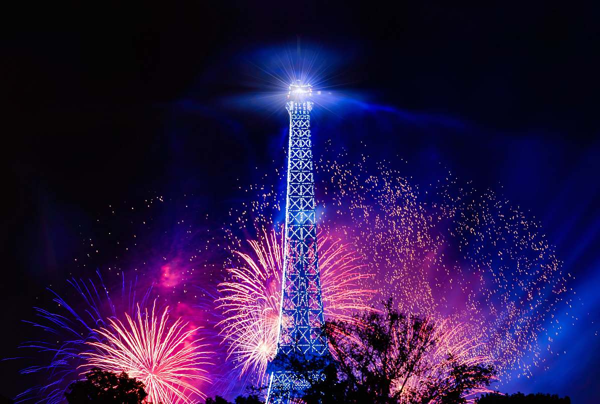night photo of eiffel tower with fireworks background outdoors
