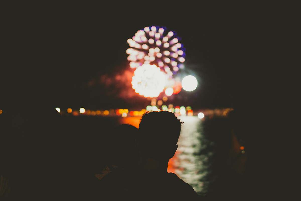 night silhouette of person in front of fireworks man