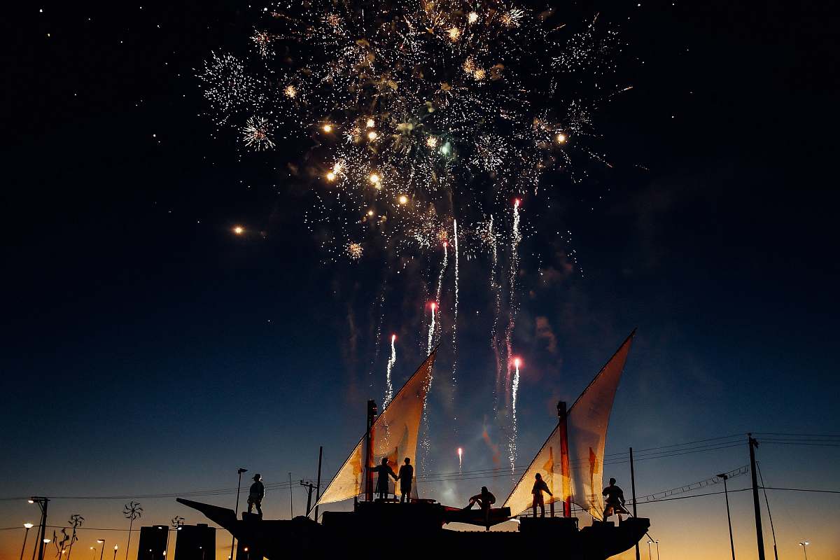 night silhouette photography of person standing while watching fireworks in the sky ship