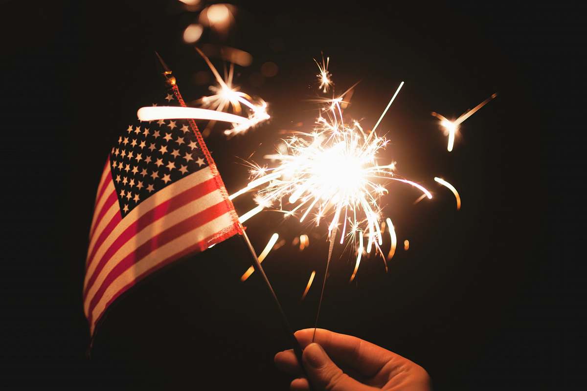 flag time lapse photography of sparkler and U.S.A flag let independence day