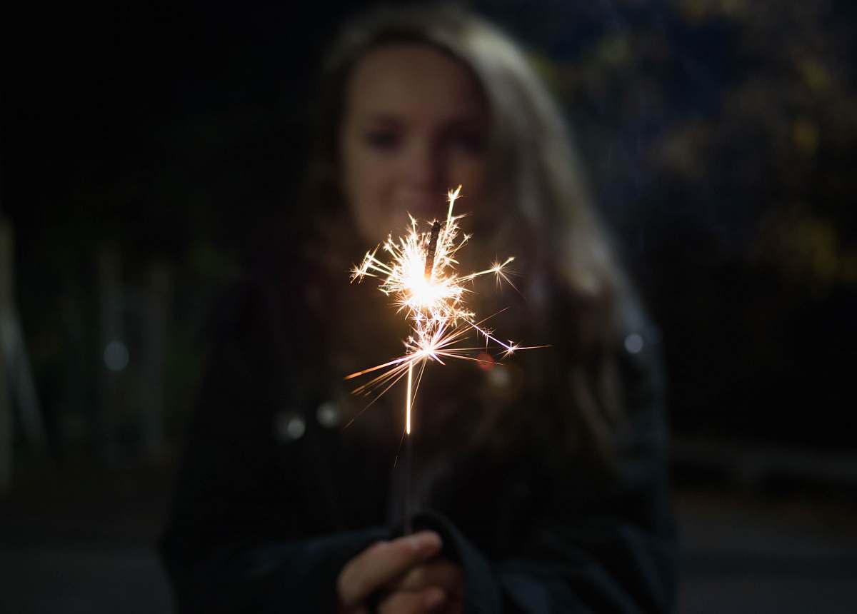 person woman holding sparkler spark