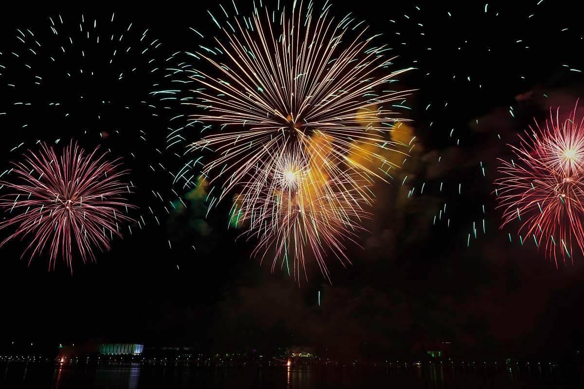 night yellow and pink fireworks display in sky outdoors