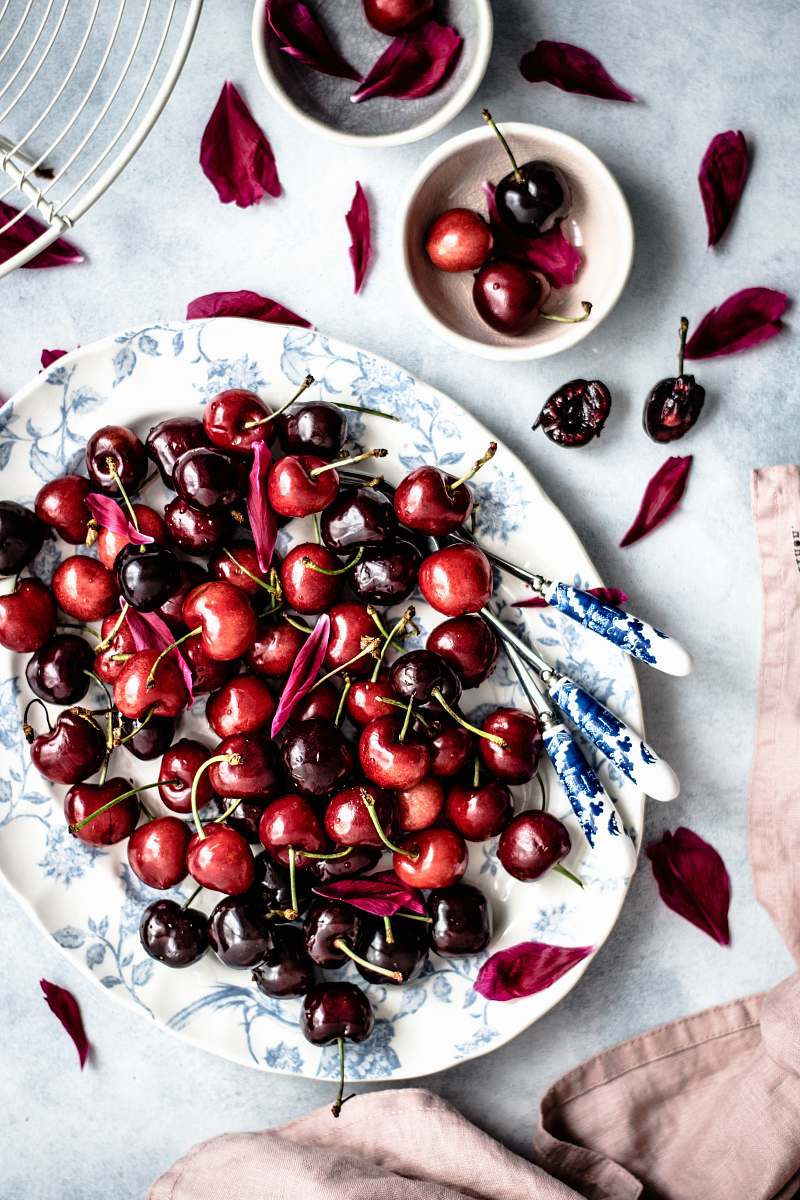 fruit red cherry fruits on oval white and blue floral ceramic plate cherry