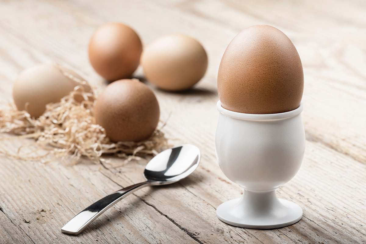 egg white ceramic egg holding near spoon brown