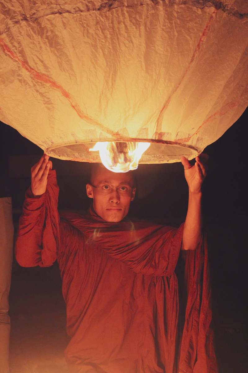 person man holding a lighted sky lantern bangladesh