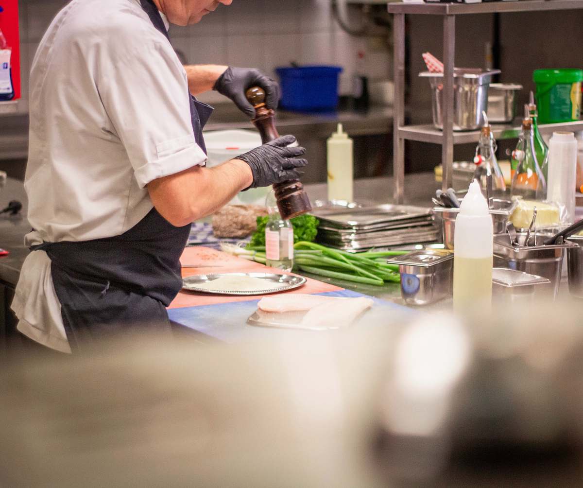 person man putting herb on food lab