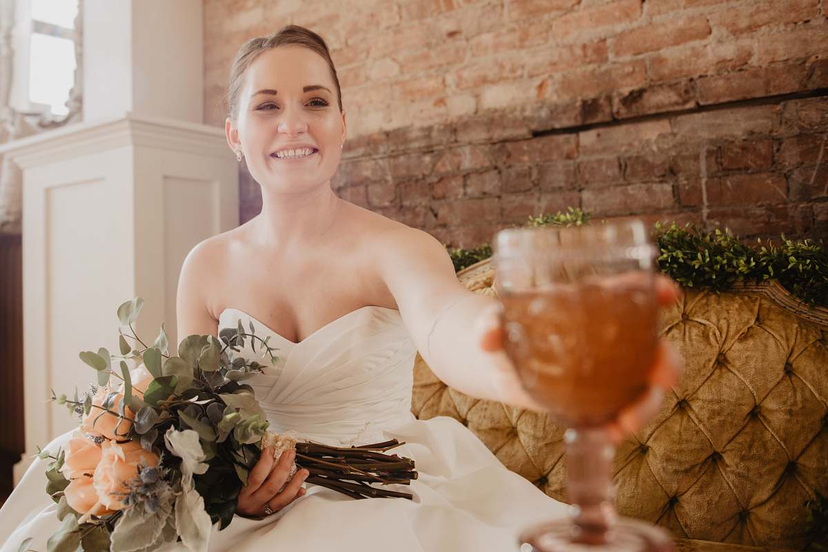 person smiling woman holding wine glass and flower bouquet plant