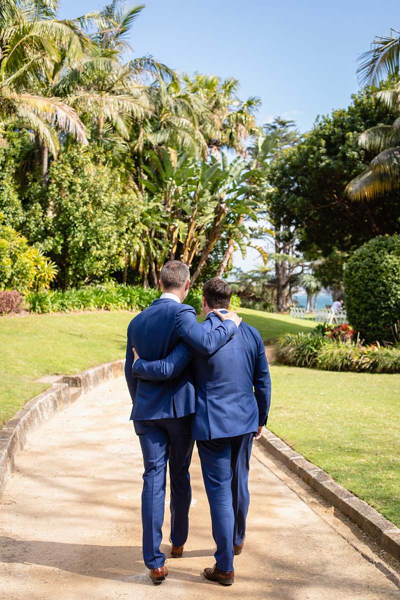 person two men walking along isle leading to beach garden