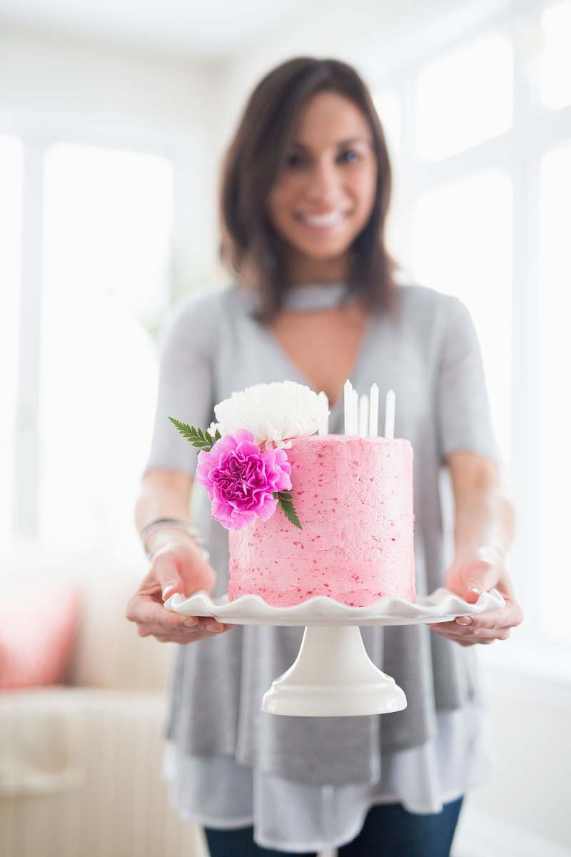 person woman holding one layer of cake with stand people